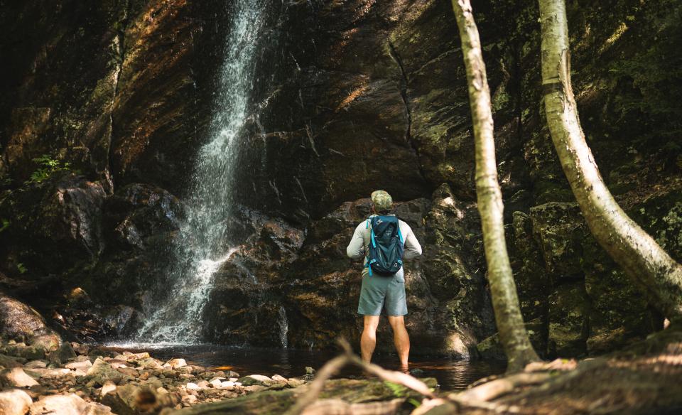A hiker at a waterfall