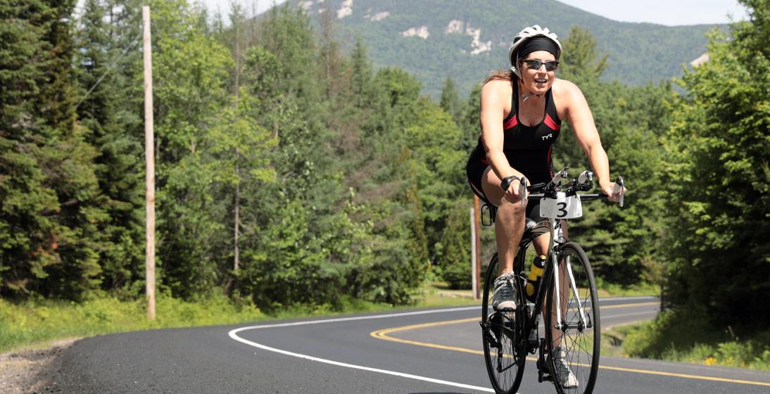 A woman biking through the Adirondacks.