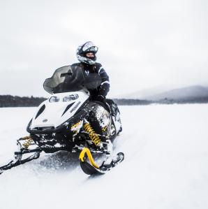 person sitting on a snowmobile on a snow covered frozen lake