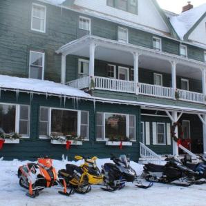 Adirondack Hotel with many snowmobiles parked outside