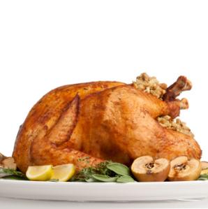 A roasted turkey on a platter with garnishings