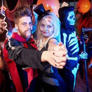 A photo of a man dressed as Dracula and a woman also dressed for halloween dancing at a party