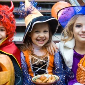 Three kids dressed up for halloween posing for a photo