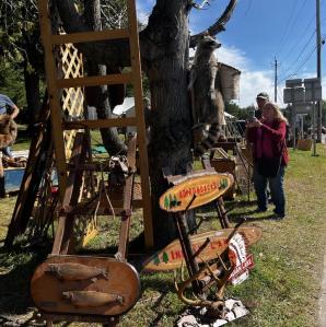 A variety of antiques on display with people browsing the items