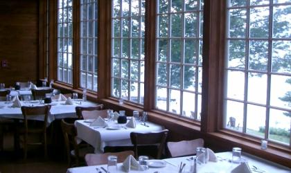 Large windows in the dining room looking out over the snowcovered grounds.