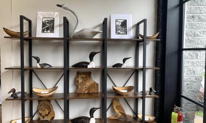A wooden and metal shelf displaying carvings