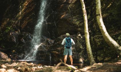 A hiker at a waterfall