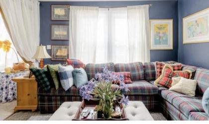 The formal sitting area with large window and plaid sectional couch