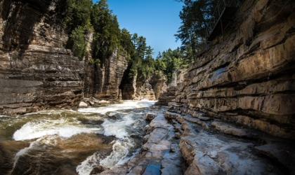 A view of the water rushing past with the towering walls of the gorge surrounding you