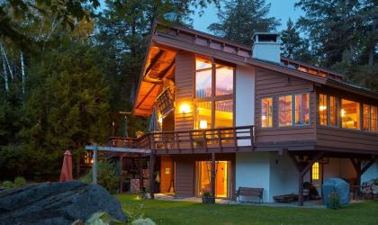 A large and warmly illuminated log cabin exterior.
