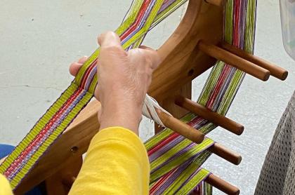 A woman creating fiber arts on a loom