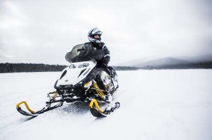 person sitting on a snowmobile on a snow covered frozen lake