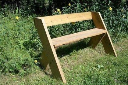 A leopold bench in a yard with green grass