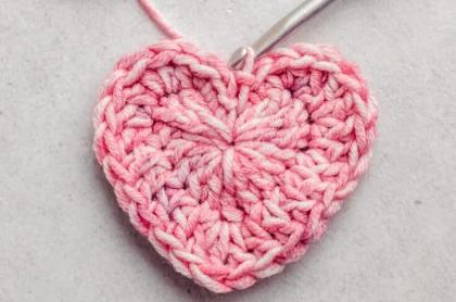 A photo of a crocheted heart with a crochet needle