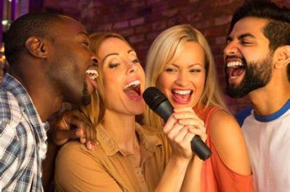 four people singing karaoke in a microphone