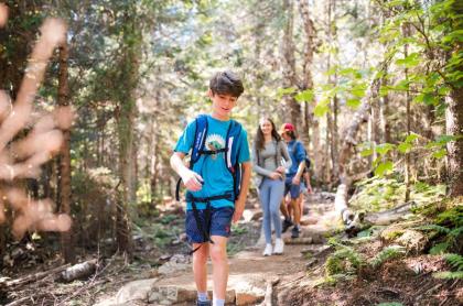 a family hiking on a trail in the forest