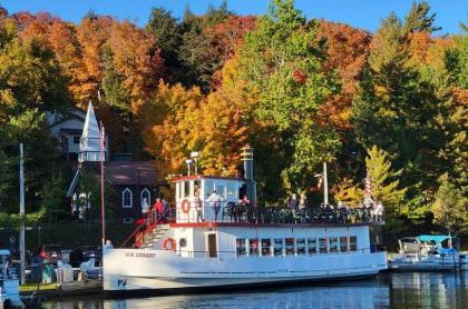 The WW Durant docked on shore with a backdrop of fall colored leaves on the trees behind it