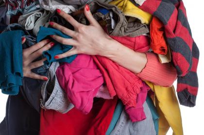 woman holding a large pile of clothes in her hands