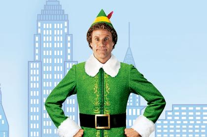 A photo of Buddy the elf standing in front of a drawing of the NYC skyline