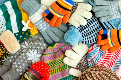picture of a pile of different winter hats and mittens