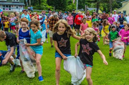 Many children in pairs doing a three-legged race