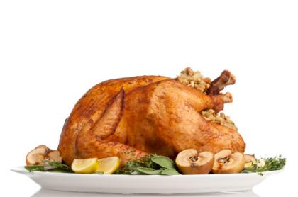 A roasted turkey on a platter with garnishings