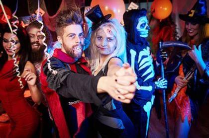 A photo of a man dressed as Dracula and a woman also dressed for halloween dancing at a party