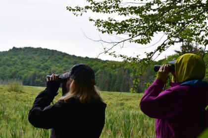 two ladies with binoculars watching for birds