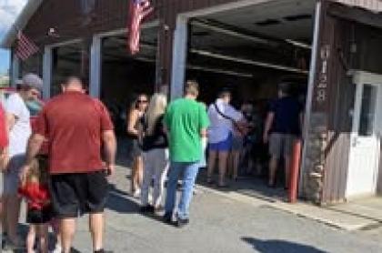 People in line at the fire department to get their chicken bbq dinner