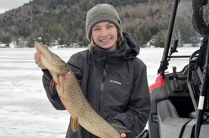 Woman holding a large fish she caught in fishing derby