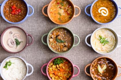 a photo of 9 different colored soup bowls with a different soup simetrically placed in rows