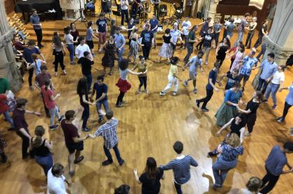 a gymnasium of people contra dancing