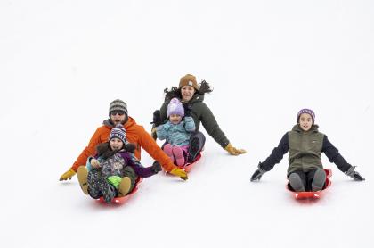 A family sledding down a hill