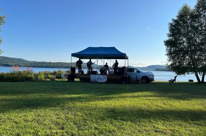 Outdoor band playing on a lakeside stage.