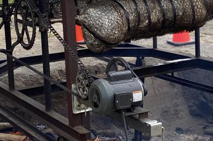 Two pigs on a spit roasting