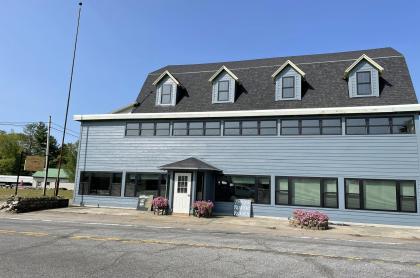 Exterior of a large building with ample parking space an a sign reading Tracy's Rustic Relics