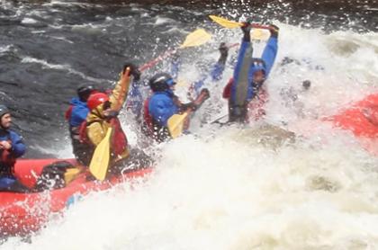 Paddles up overhead while hitting the white water