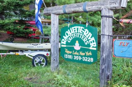 The green sign for Raquette River Outfitters
