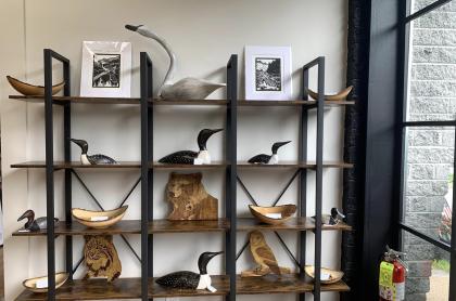 A wooden and metal shelf displaying carvings