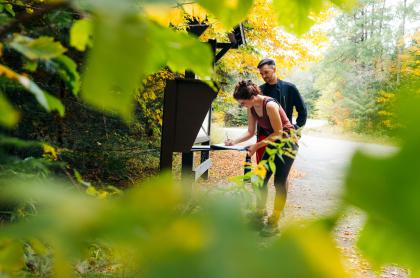 A couple signing into the Goodman Mountain trailhead register