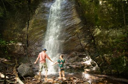 Two people at the base of Cascade Lake Falls