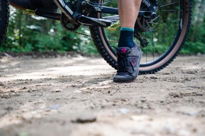 A close up of a bicycle wheel and foot