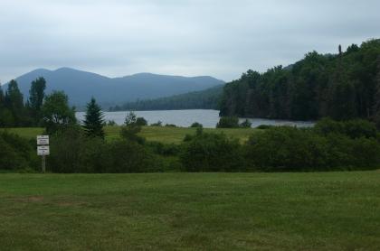 A small lake nestled amongst mountains and green trees