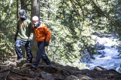 Two males hiking with Auger Falls' spring run behind them