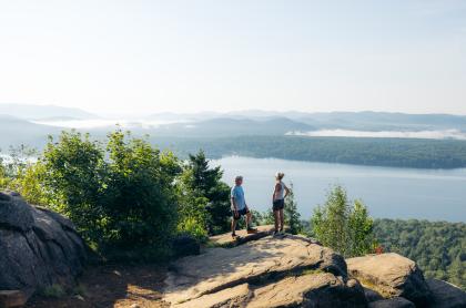An older couple on a mountain overlooking a lake