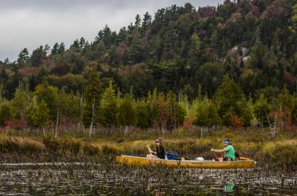 A C2 canoe in a shallow river in the fall