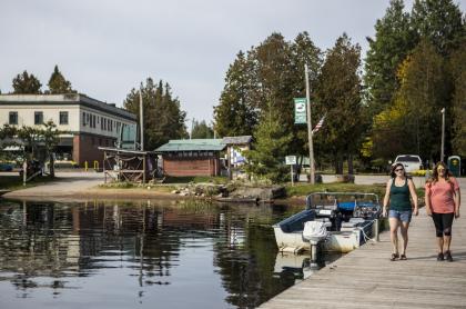Two people on a dock next to a boat launch