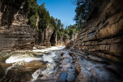 A view of the water rushing past with the towering walls of the gorge surrounding you