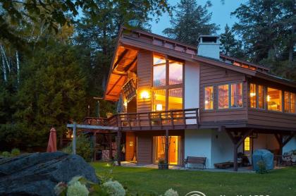 A large and warmly illuminated log cabin exterior.