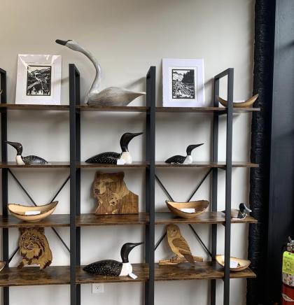 A wooden and metal shelf displaying carvings